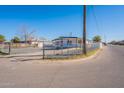 Street view showcasing a single-story home with fenced yard and a convenient covered parking area at 683 W Shannons Way, Coolidge, AZ 85128