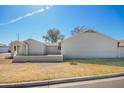 Single-story house featuring a spacious yard, block wall, an open carport and mature trees at 7018 S 41St Pl, Phoenix, AZ 85042