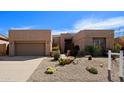 Contemporary home with desert landscaping, two-car garage, and a clean, modern facade at 7019 E Thirsty Cactus Ln, Scottsdale, AZ 85266