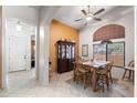 Bright dining room with large window, a wooden table with seating for six, and tile flooring at 7232 E Nance St, Mesa, AZ 85207