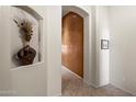 Inviting hallway with an arched alcove and neutral tile floors, showcasing the home's elegant design at 7232 E Nance St, Mesa, AZ 85207