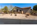 Tan home on a corner lot with desert landscaping, and a tile roof in an upscale community at 7232 E Nance St, Mesa, AZ 85207