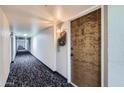 Hallway with carpet leading to unit 403's decorative brown front door at 7940 E Camelback Rd # 403, Scottsdale, AZ 85251