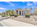Charming home with desert landscaping featuring palm trees, rock features, and lush green shrubbery at 9167 E Tarantini Ln, Scottsdale, AZ 85260