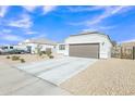 Single-story home boasting low-maintenance desert landscaping and a wide driveway leading to a two-car garage at 10320 E Lupine Ln, Florence, AZ 85132