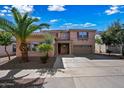 Charming two-story home with a well-manicured lawn and a spacious driveway leading to an attached two-car garage at 13569 W Ventura St, Surprise, AZ 85379