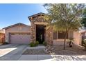 Charming single-Gathering home featuring a stone column entrance and a well-manicured front yard at 16561 W Cielo Grande Ave, Surprise, AZ 85387