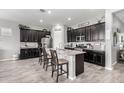 Beautiful kitchen with dark wood cabinets, stainless steel appliances, and a large center island with seating at 16561 W Cielo Grande Ave, Surprise, AZ 85387