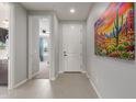 Inviting home entryway featuring neutral gray walls, decorative painting, and sleek tile flooring throughout at 17762 W Granite View Dr, Goodyear, AZ 85338