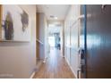 Inviting foyer features wood-look tile flooring and decorative wall panels with a view towards the living area at 1940 W Kinfield Trl, Phoenix, AZ 85085