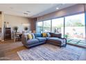 Stylish living room with a large sectional, an area rug, and expansive glass sliding doors to the patio at 1940 W Kinfield Trl, Phoenix, AZ 85085