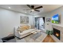 Cozy living room with fireplace and sliding glass door to balcony with seating, wood-look floors at 2025 E Campbell Ave # 227, Phoenix, AZ 85016