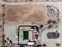 Expansive aerial view featuring large horse arena, turf yard, and desert landscaping at 21433 W Caravaggio Ln, Wittmann, AZ 85361