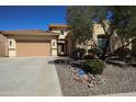 Inviting single-story home featuring a tile roof, well-manicured desert landscaping, and a secure ADT security system at 31483 N 133Rd Dr, Peoria, AZ 85383