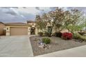 Inviting home featuring a tiled roof, mature desert landscaping, and a secure gated entry at 31483 N 133Rd Dr, Peoria, AZ 85383