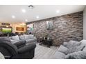 A Stylish living room features a stone accent wall, recessed lighting, and modern furnishings at 3342 N 63Rd Ave, Phoenix, AZ 85033