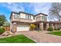 Charming two-story home featuring a well-maintained lawn, brick driveway, and a welcoming facade at 3744 E Sierra Madre Ave, Gilbert, AZ 85296