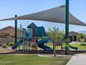 Community playground featuring multiple slides and climbing structures with shade, grass, and nearby homes at 3823 S 87Th Dr, Tolleson, AZ 85353