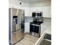 Updated kitchen boasting stainless steel appliances, white cabinets, and attractive countertops at 4038 E Burgess Ln, Phoenix, AZ 85042