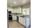 Bright kitchen features white cabinets, stainless steel appliances, and a double sink beneath a large window at 4038 E Burgess Ln, Phoenix, AZ 85042