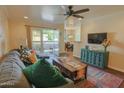 Bright living room with hardwood floors, a ceiling fan, and sliding glass door to the balcony at 4120 N 78Th St # 217, Scottsdale, AZ 85251