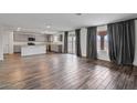 Open-concept living space with wood-look floors, leading to sliding doors, and adjacent to a modern kitchen at 618 E Elm Ln, Avondale, AZ 85323