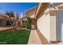 Inviting home entrance with desert landscaping, walkway and ample lawn space at 6834 S Dennis Dr, Tempe, AZ 85283