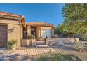 Inviting single-story home with gated front patio and desert landscaping with a tiled roof at 9130 E Crystal Dr, Sun Lakes, AZ 85248