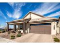 Charming single-story home featuring a covered porch, desert landscaping, and a two-car garage at 9716 E Resistance Ave, Mesa, AZ 85212