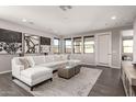 Spacious living room featuring a large white sofa, area rug, recessed lighting, and multiple windows at 9716 E Resistance Ave, Mesa, AZ 85212