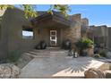 Inviting front entrance with stone accents, well manicured landscaping and a stone pathway leading to the front door at 9887 E Palo Brea Dr, Scottsdale, AZ 85262