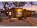 Inviting home with desert landscaping, a stone bench, and large picture window showcasing a bright interior at 10611 N 9Th Dr, Phoenix, AZ 85029