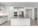 Bright and airy kitchen with white cabinets, stainless steel appliances, gray countertops, and a kitchen island at 11620 W Marguerite Ave, Avondale, AZ 85323