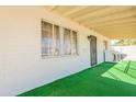 Charming porch area features a protective gate and artificial turf providing a welcoming outdoor space at 12010 N 113Th Ave, Youngtown, AZ 85363