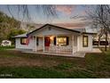 Inviting home with a covered porch, American flag, and charming curb appeal at 17335 W Cheryl Dr, Waddell, AZ 85355