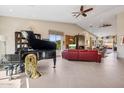 Open-concept living room with a grand piano, red leather sofa, vaulted ceilings, and fireplace at 17366 E Via Del Oro St, Fountain Hills, AZ 85268