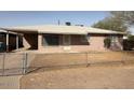 A single-story home featuring bars on the windows and a basic, fenced yard at 1950 E Wier Ave, Phoenix, AZ 85040