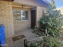 Welcoming front entrance with brick facade, complemented by a well-manicured garden and secure front door at 2423 E Flower St, Phoenix, AZ 85016