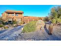 Expansive home featuring a stone address marker, desert landscaping, and attached garages on a sunny day at 28503 N 104Th Way, Scottsdale, AZ 85262