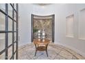 Elegant home foyer featuring tile floors, a decorative table with candles, and an arched stone accent wall at 28503 N 104Th Way, Scottsdale, AZ 85262