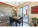 Dining area with stone accent wall, a dark wood table and chairs, and sliding door access to patio at 2868 E Dunbar Dr, Phoenix, AZ 85042