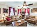 Cozy living room with wood-look flooring, leather sofas, decorative accents, and bright natural light at 2868 E Dunbar Dr, Phoenix, AZ 85042