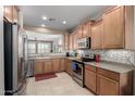 Traditional kitchen with light wood cabinets, stainless steel appliances, and a tiled backsplash at 29986 N Jillian Dr, San Tan Valley, AZ 85143