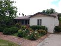 Charming single-story home featuring a colorful front yard garden with vibrant flowers and lush greenery at 32 E 14Th St, Tempe, AZ 85281