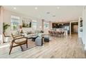 Bright and airy living room flows into dining area and kitchen, featuring wood floors and ample natural light at 38233 N Stillmeadow Rd, San Tan Valley, AZ 85140