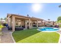 Expansive backyard featuring a pristine pool, lush turf, and covered patio ideal for outdoor entertaining at 4502 E Meadow Dr, Phoenix, AZ 85032