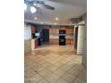 Spacious kitchen featuring wood cabinets, tile floors, and modern appliances at 6617 W Peck Dr, Glendale, AZ 85301