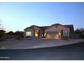 Well-maintained single-story home featuring desert landscaping as seen at dusk at 7910 E Snowdon Cir, Mesa, AZ 85207