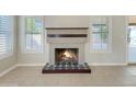 Close-up of the living room fireplace with decorative tile and a wooden mantle, flanked by shuttered windows at 8661 N 108Th Ln, Peoria, AZ 85345