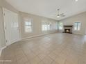 Bright living room features tile floors, multiple windows with shutters, and a cozy fireplace at 8661 N 108Th Ln, Peoria, AZ 85345